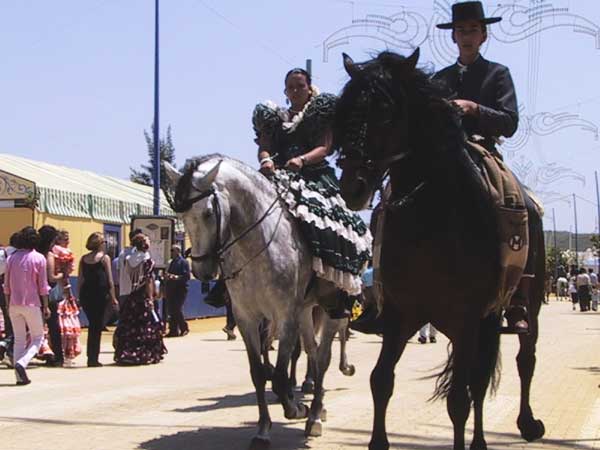 Spaans geklede amazone en ruiter op Andalusische paarden