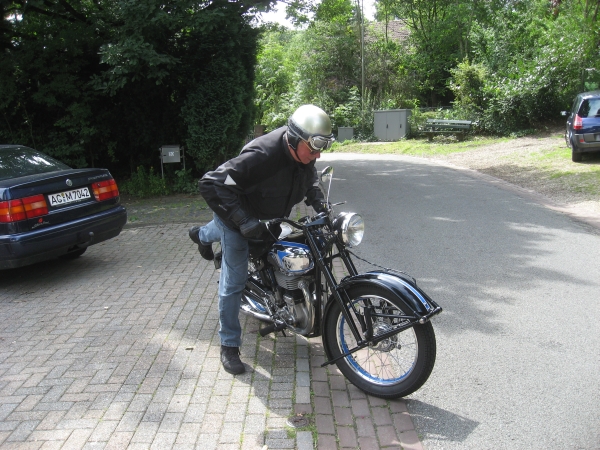 Een oudere man op een oudere motor